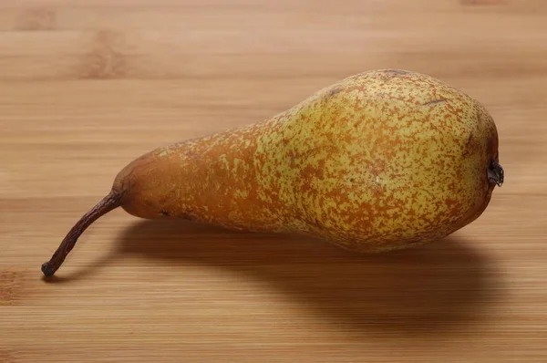 Ripe yellow pear on wooden rattan bamboo table — Stock Photo, Image