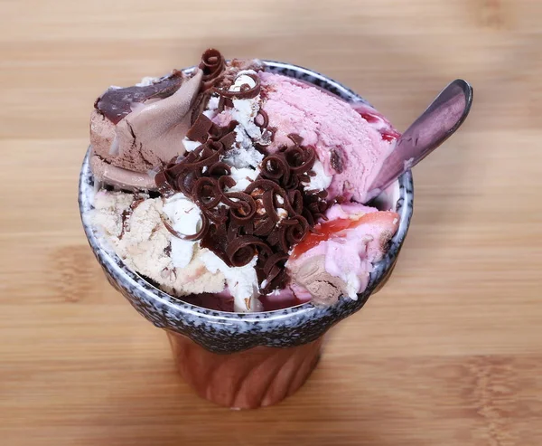 Gelado de frutas e chocolate na tigela na mesa de bambu de vime de madeira — Fotografia de Stock