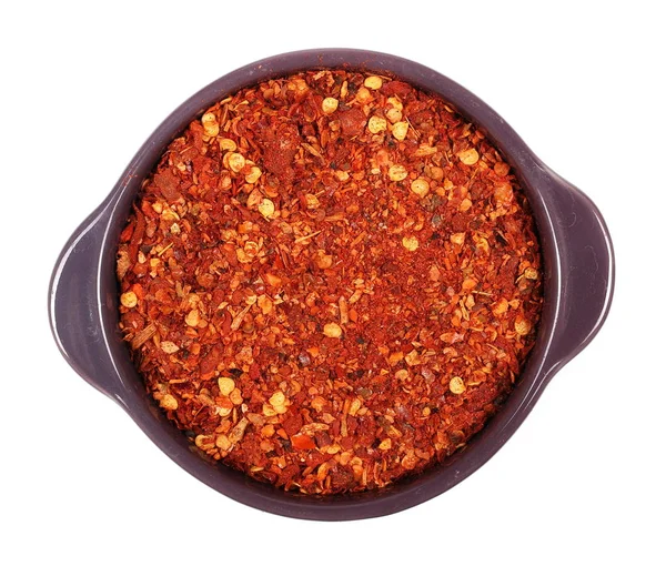 Kupie pokruszony czerwony pieprz cayenne, suszonych płatków chili i nasiona w porcelanowe na białym tle — Zdjęcie stockowe