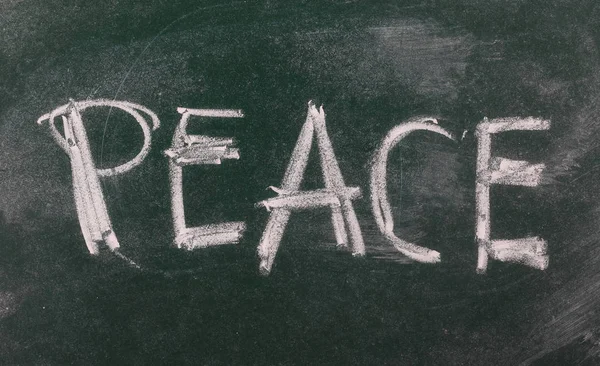 Word peace on chalkboard, blackboard texture — Stock Photo, Image