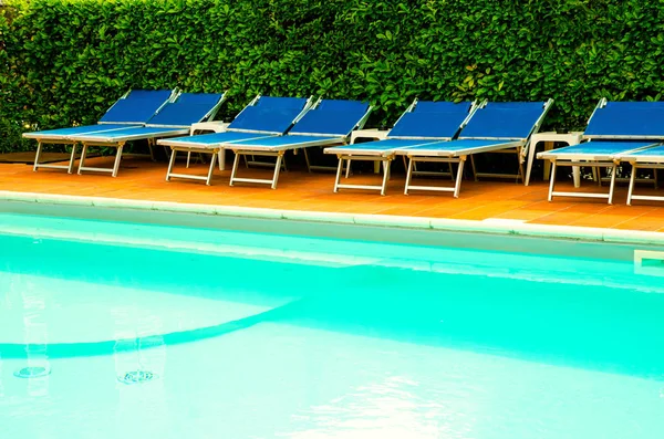 pool with chaise-longues in hotel