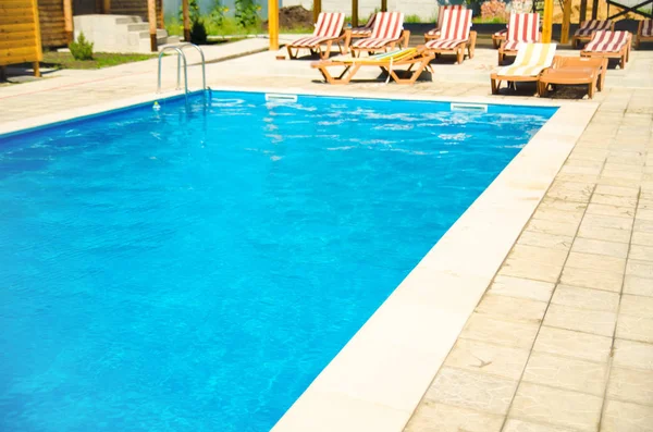 pool with chaise-longues in hotel