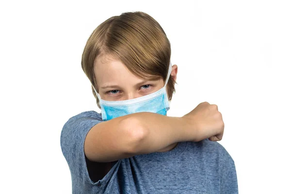 年轻的少年戴着防护面罩 肘部咳嗽 与白种人隔离 图库图片