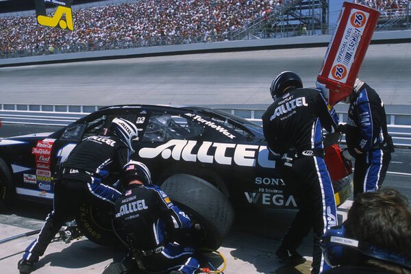 Pit Crews work on cars during a NASCAR race.