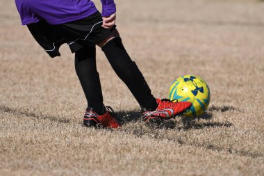 Çocuklar koşup futbol topunu tekmeliyor. 8-10 yaş arası erkek futbol takımlarının stadyumda oynadıkları futbol maçını yakından takip ediyoruz..