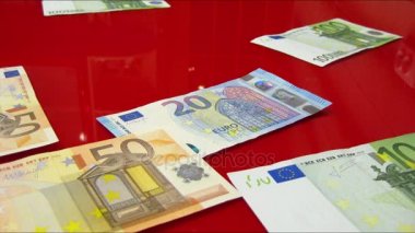 Bir kırmızı cam yüzey üzerinde görünen euro banknot