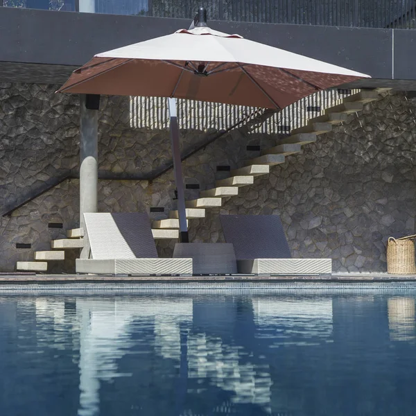 Leżaki i parasol przy basenie — Zdjęcie stockowe