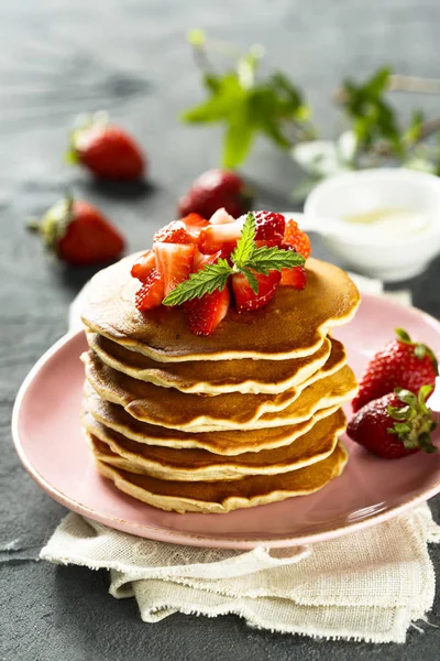 Homemade fluffy pancakes with strawberry and syrup