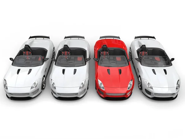 Красный спортивный автомобиль выделяется среди белых спортивных автомобилей - вид сверху вниз — стоковое фото