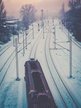Tren karla kaplı tren raylarından geçiyor.