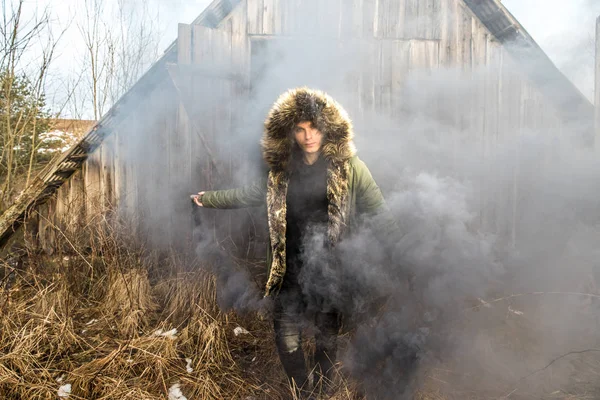 Young man posing with a smoke bomb.