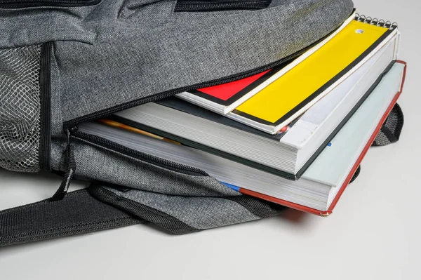 Mochila escolar em fundo branco com livros e cadernos em espiral — Fotografia de Stock