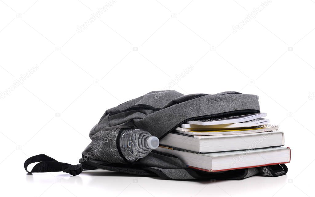 School backpack on a white background with books and spiral notebooks