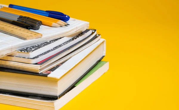 Livros escolares e suprimentos em um fundo amarelo — Fotografia de Stock