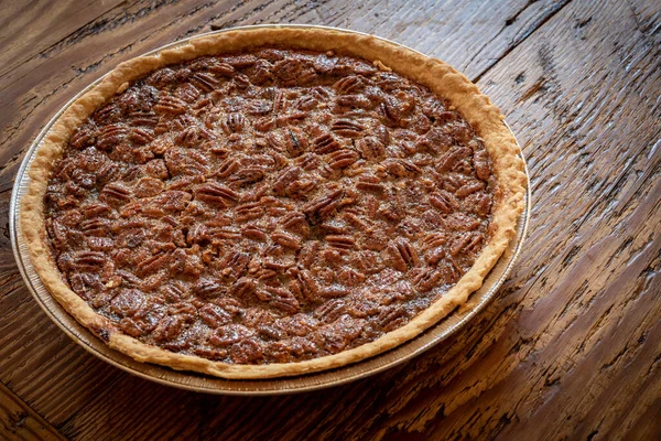 Torta de noz pecã assada fresca em uma mesa de madeira — Fotografia de Stock