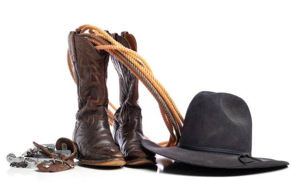 Stivali occidentali e una corda da ginnastica o da lariat e speroni e un cappello da cowboy su sfondo bianco — Foto Stock