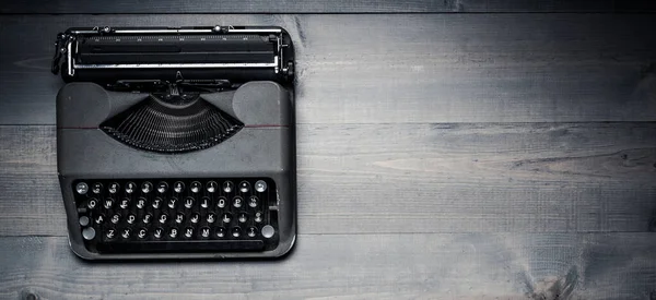 Vintage, antieke typemachine op een grijze houten achtergrond — Stockfoto