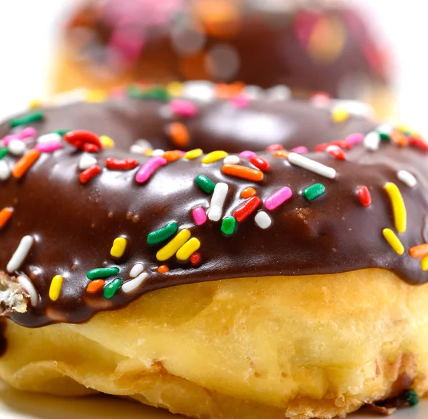 Rosquillas vidriadas de chocolate con salpicaduras sobre un fondo blanco Imágenes de stock libres de derechos