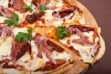 Ahşap tabakta servis edilen ev yapımı jambonlu pizza..