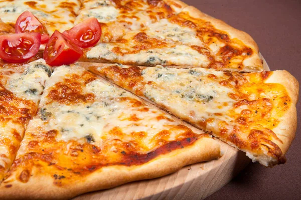Tahta tabakta servis edilen peynirli, otlu ve kiraz domatesli ev yapımı pizza.