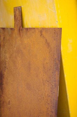 Sarı arka planda çok eski paslı metal bir plaka. Metal levha. Eski bir temel. Grunge duvar kapısı..