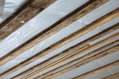 Yeni evin çatısının içeriden izolasyonu. Görünür çatı elementleri, yalıtım, ahşap.