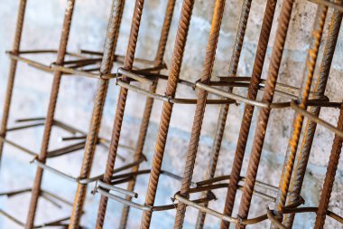 Metal kaplı metal kolonlar beton dökmek için duvara dayanıyor. İnşaat için metal takviye kemeri üretimi.