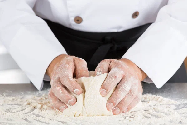 Baker pétrissant la pâte avec ses mains — Photo