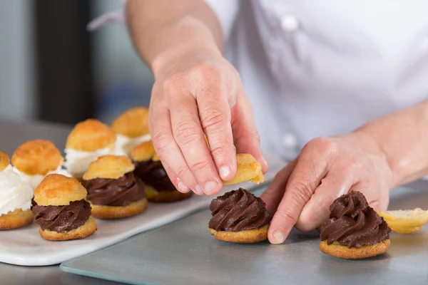 Şef biraz profiterol dekorasyon — Stok fotoğraf