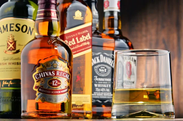 Composizione con vetro e bottiglie di diverse marche di whisky — Foto Stock