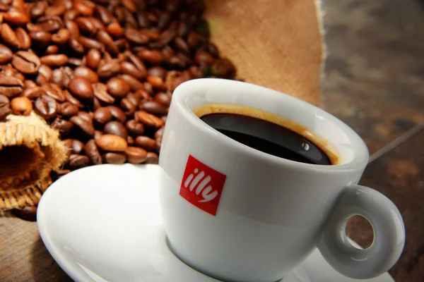 Composição com xícara de café Illy e grãos — Fotografia de Stock
