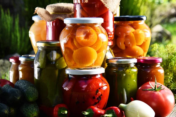 Potten van ingemaakte groenten en fruit in de tuin — Stockfoto