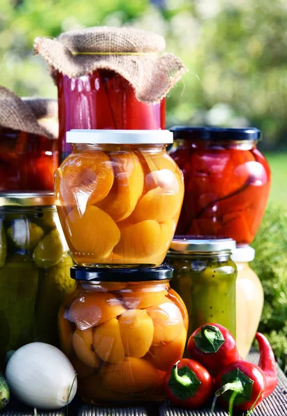 Jars of pickled vegetables and fruits in the garden — Stock Photo, Image