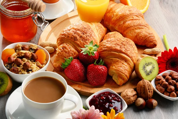 Frühstück bestehend aus Croissants, Kaffee, Obst, Orangensaft — Stockfoto