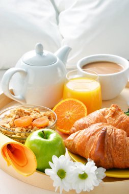 Otel odasında yatakta kahvaltı tepsisi