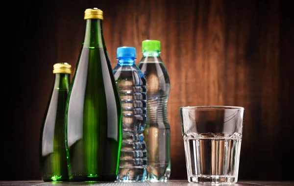 Состав со стеклом и бутылками минеральной воды — стоковое фото