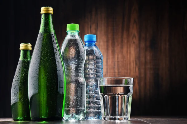 Состав со стеклом и бутылками минеральной воды — стоковое фото