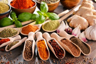 Mutfak masasında çeşitli baharat ve bitkiler var.