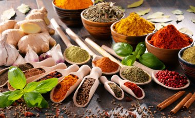 Mutfak masasında çeşitli baharat ve bitkiler var.