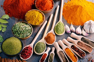 Mutfak masasında çeşitli baharat ve bitkiler var.