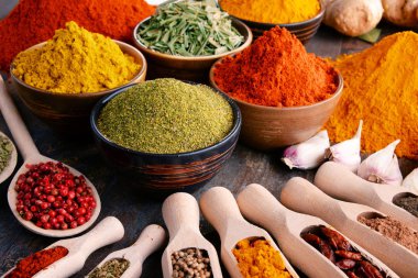 Mutfak masasında çeşitli baharat ve bitkiler var.