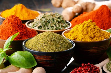 Mutfak masasında çeşitli baharat ve bitkiler var.