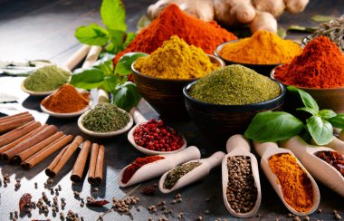 Mutfak masasında çeşitli baharat ve bitkiler var.