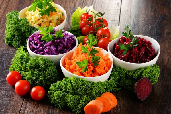 Composition with four vegetable salad bowls on wooden table — Stock Photo, Image