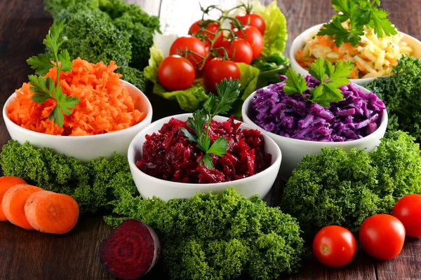 Composición con cuatro ensaladeras de verduras sobre mesa de madera — Foto de Stock