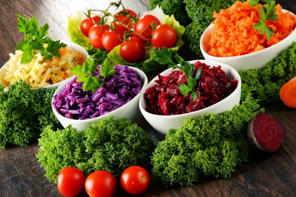 Composition with four vegetable salad bowls on wooden table — Stock Photo, Image
