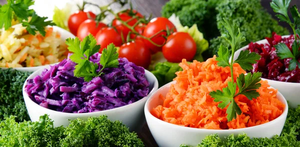 Composition with four vegetable salad bowls on wooden table — Stock Photo, Image