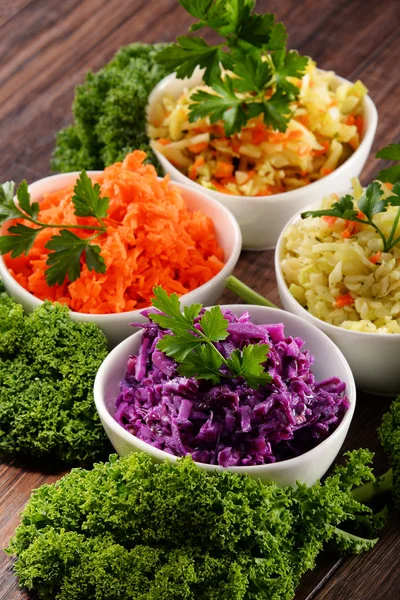 Composition with four vegetable salad bowls on wooden table — Stock Photo, Image