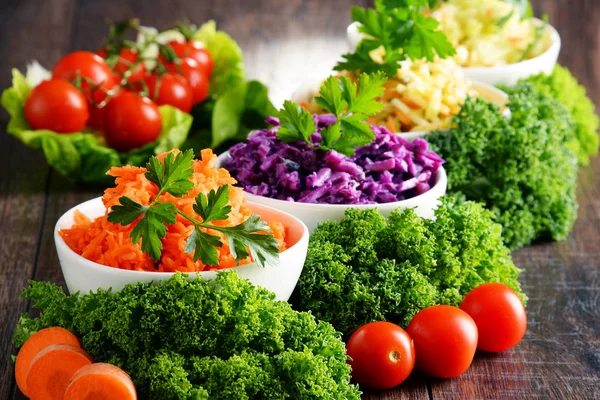 Composition with four vegetable salad bowls on wooden table — Stock Photo, Image