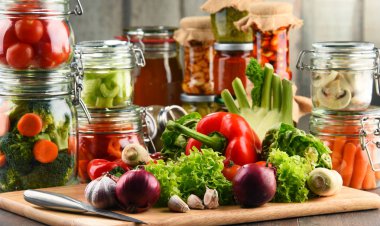 Kavanoz ile marine edilmiş yiyecek ve çiğ sebze kesme tahtası üzerinde